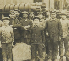 Groupe d'ouvriers datée de 1916. En pleine période de guerre, on y retrouve de nombreux adolescents et hommes d'âge mur.