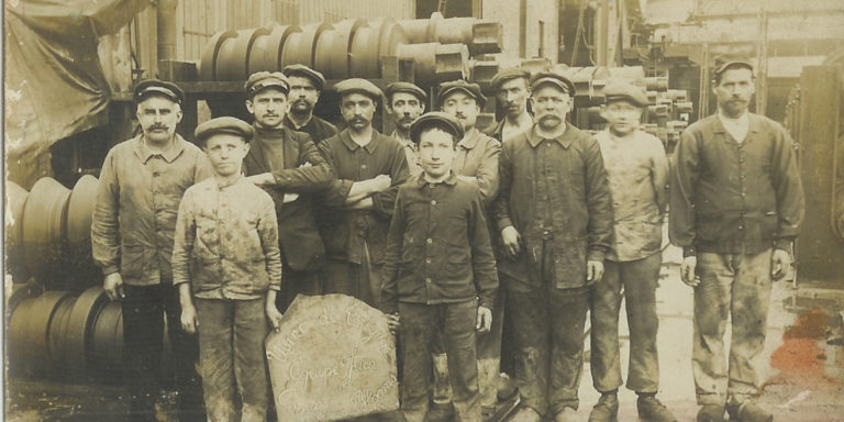 Groupe d'ouvriers datée de 1916. En pleine période de guerre, on y retrouve de nombreux adolescents et hommes d'âge mur.